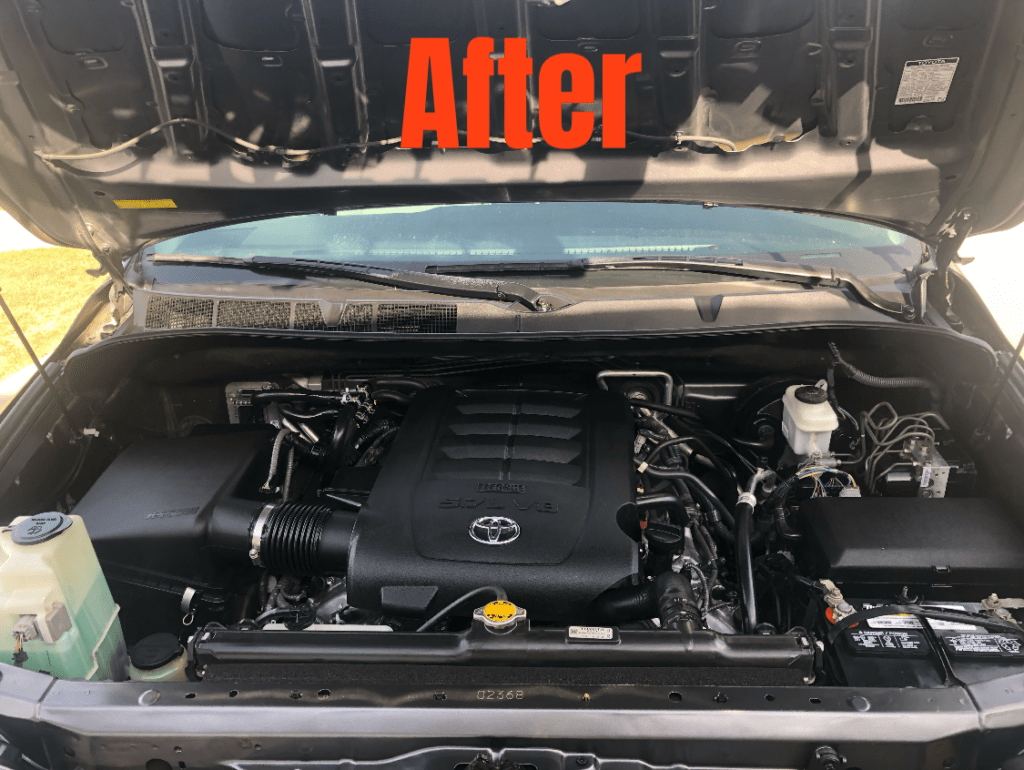 An after state of a car engine cleaned detailed with the hood open.