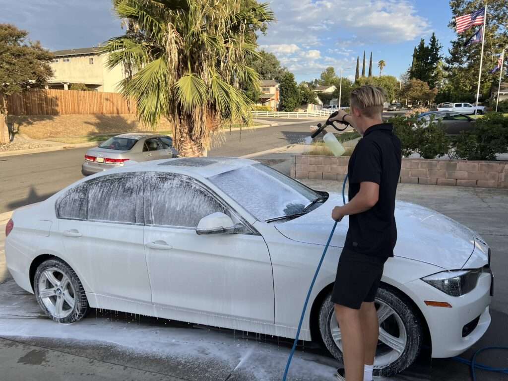 IMG_6116-compressed Our assistant washing a white BMW car with a hose.